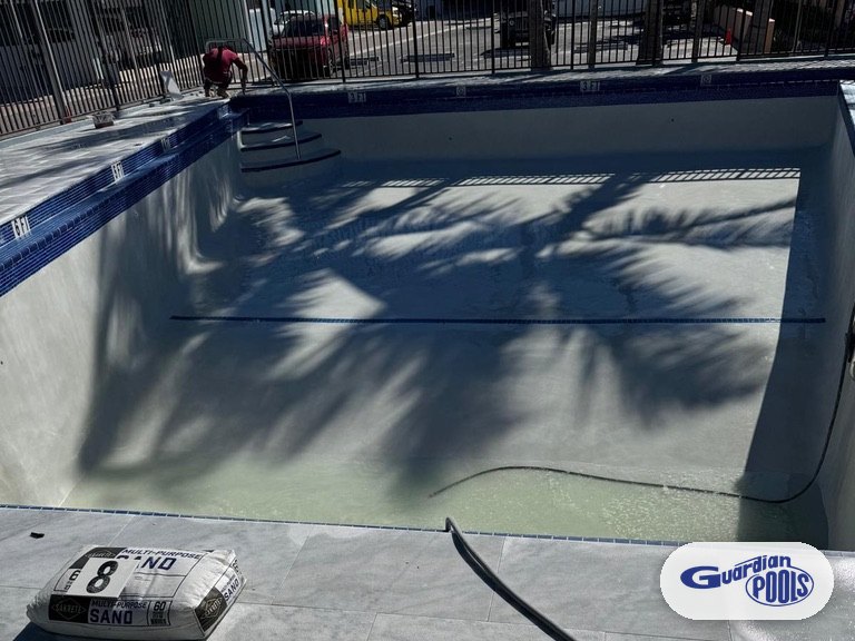 Drained beachside condominium pool in Hollywood during renovation, seen from the pool deck